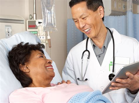 Doctor holding tablet talks with smiling patient - Harbor Health Services