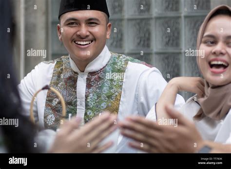muslim man and woman smile and laughing while having greeting at dining table during lunch and ...