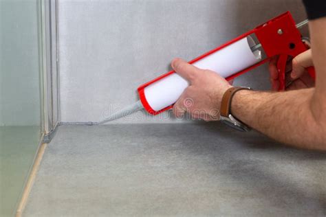 A Plumber Applies Silicone Sealant To the Joining of Ceramic Tiles in the Bathroom Stock Photo ...