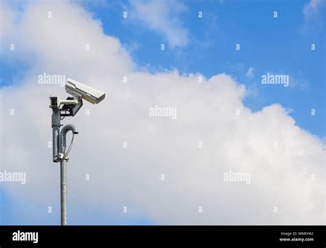 Security camera install corner outside of building with blue sky background Stock Photo - Alamy