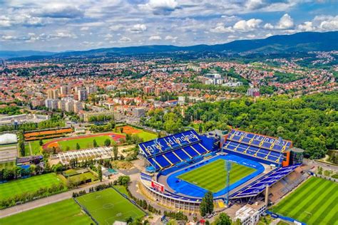 an aerial view of a soccer stadium in the middle of a city with mountains in the background