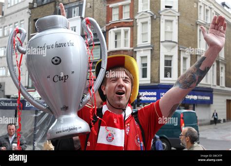 Supporter of Bayern Munich holds a mock-up Champions League trophy in ...