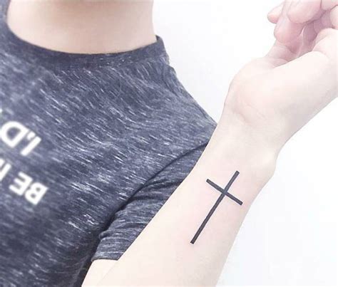 Christian cross tattoo on the wrist.