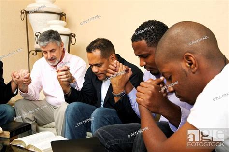 a group of men praying together with an open bible, Stock Photo, Picture And Royalty Free Image ...