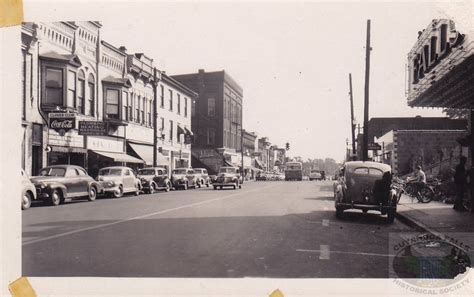 an old black and white photo of cars driving down the street