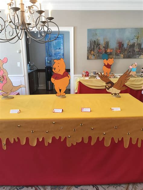 winnie the pooh themed birthday party with decorations and table cloths, including paper cutouts