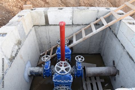 Gate valves in valve pit of the underground piping networks. Laying water system pipeline at ...