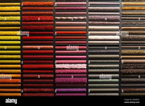 Samples of carpets of different colors on a stand in a store or ...