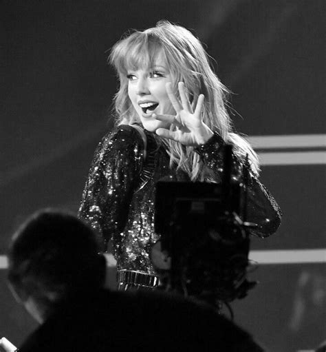taylor swift performing on stage in black and white