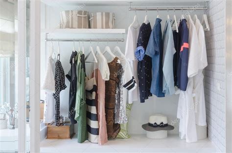 Clothes hanging in closet with hat Stock Photo by ©khongkitwiriyachan ...