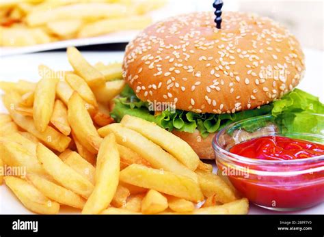 Burger with french fries and bowl of ketchup on white plate Stock Photo ...