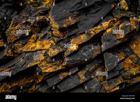 black rock background with gold / yellow colored rocks Stock Photo - Alamy