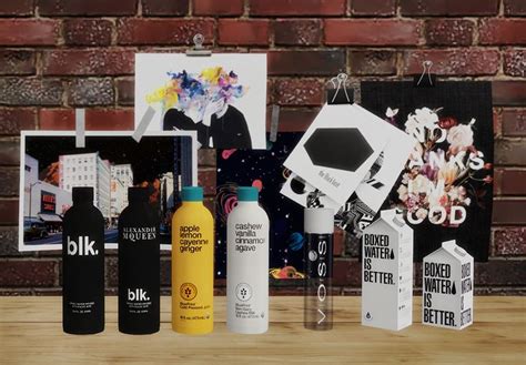 an assortment of different types of bottles on a wooden table next to a brick wall