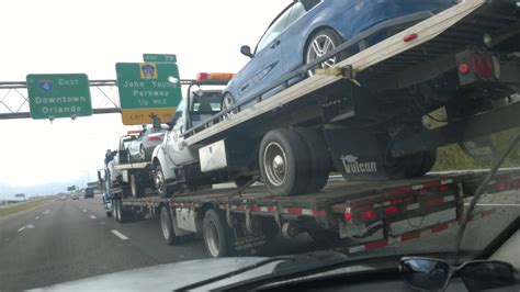 A tow truck towing two tow trucks each towing a car. : mildlyinteresting