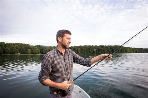 Side view of man is fly fishing from a boat on lake. — fisher, countryside - Stock Photo ...