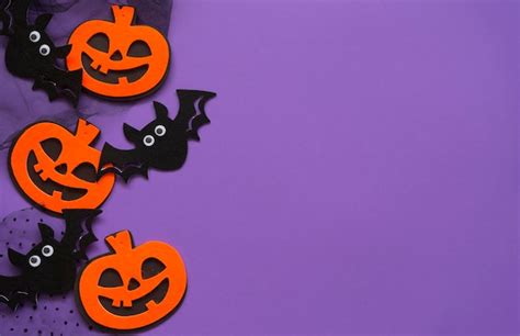 Premium Photo | Halloween pumpkin and bat figurines on purple background