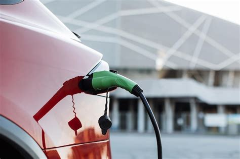 Premium Photo | Close up of red luxury electric car charging on station