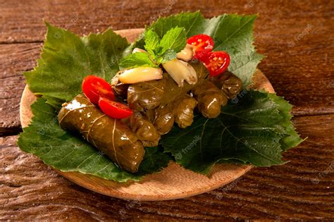 Premium Photo | Sarma - Rice and mint wrapped in grape vine leaves on wood background.