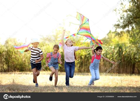 Little children flying kites outdoors Stock Photo by ©serezniy 293998664