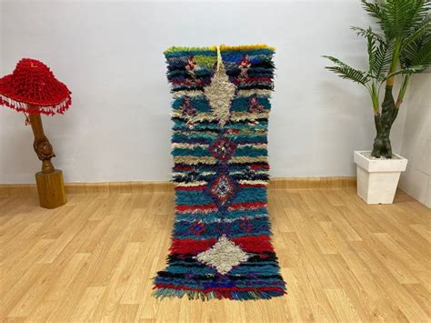 a colorful rug is on the floor next to a potted plant and vases