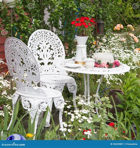 Garden Furniture Set With Flowers Growing In Garden Stock Image - Image ...