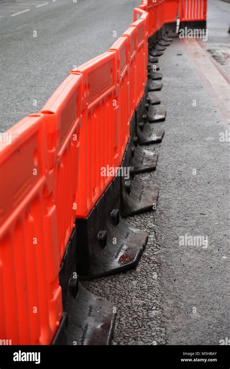 A photo of a temporary walkway with plastic safety barriers on a roadwork site Stock Photo - Alamy