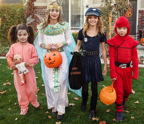 Group of kids dressed in Halloween costumes going trick or treating ...