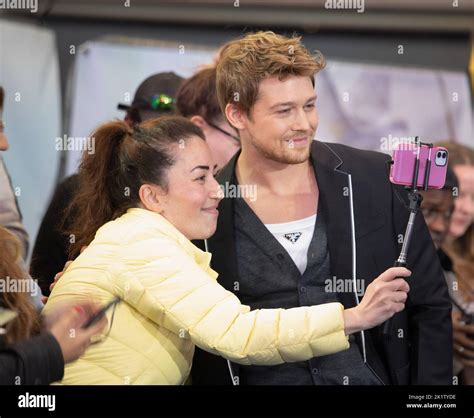 Joe Alwyn poses for a photograph with a fan while attending the UK ...