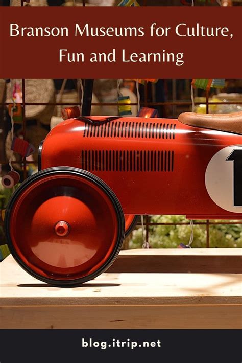 a red toy car sitting on top of a table next to a sign that says branon ...