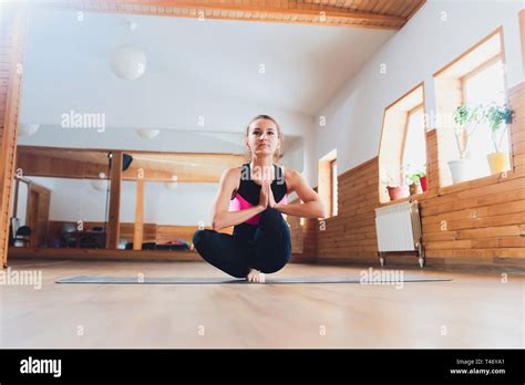 young woman doing one legged squat yoga pose outdoors Stock Photo - Alamy