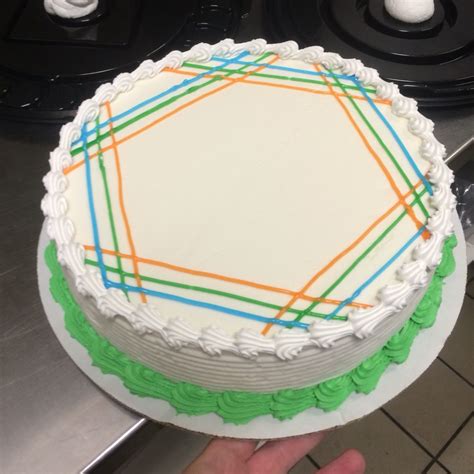 a cake with white frosting and colored lines on it is being held by a ...