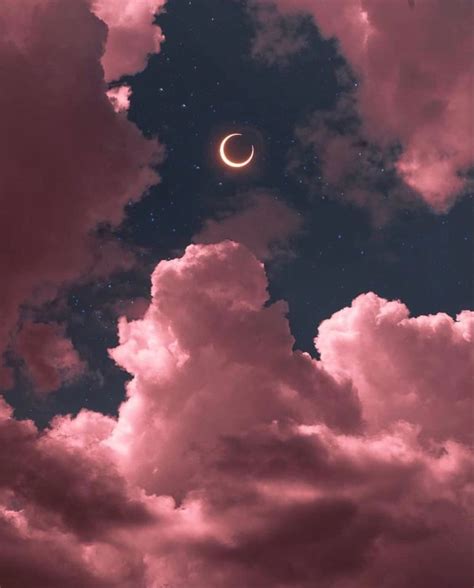 the moon is in the cloudy sky with pink clouds and blue stars above it, as well as an eclipse