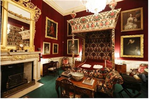 a bedroom with red walls and paintings on the wall, including a bed in an ornately decorated room