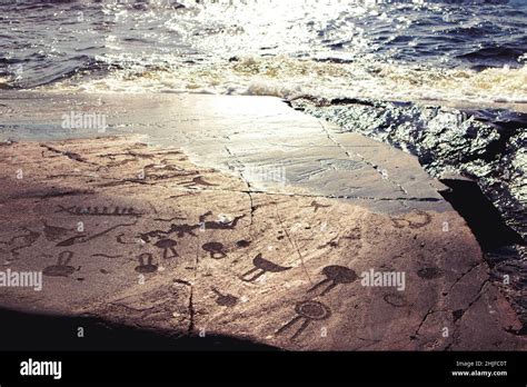 Ancient petroglyphs on the shores of Lake Onega. Carved on a granite slab. Cape Besov Nos ...