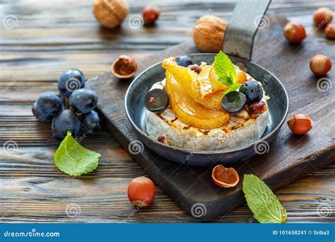 Baked Camembert with Pears, Black Grapes and Hazelnuts. Stock Image - Image of french, sauce ...