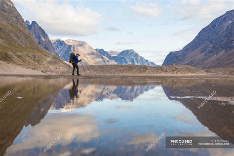 Reflection of backpack hiking in Akshayuk Pass, Baffin Island, Canada ...