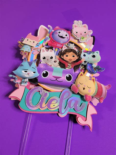 a purple cake topper with various cartoon characters on it