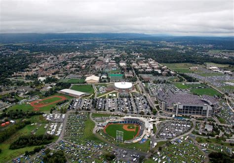 an aerial view of a baseball field and parking lot in a city with lots of cars