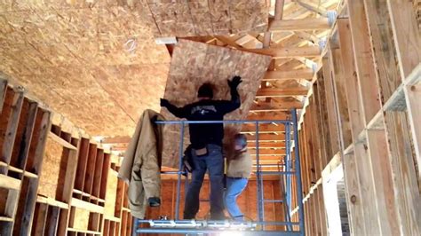 Hanging OSB plywood on a high ceiling a scaffold and two people. - YouTube