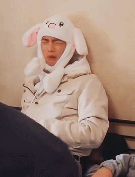 a man wearing a bunny hat sitting on top of a bed
