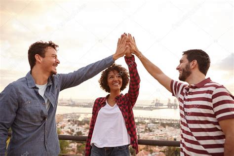 Three smiling friends doing high five — Stock Photo © pablocalvog ...