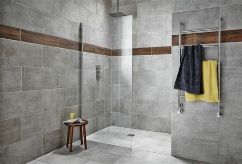 salle de bains avec carrelage gris mural et de sol avec frise marron, douche italienne avec ...