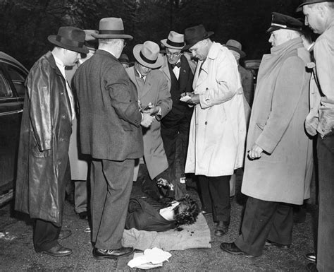 Detectives examine the body of Evans. (Pittsburgh Press photo)