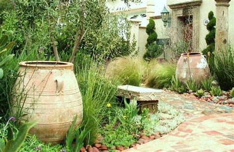 CA Mediterranean garden with olive tree, succulents, antique olive jars ...