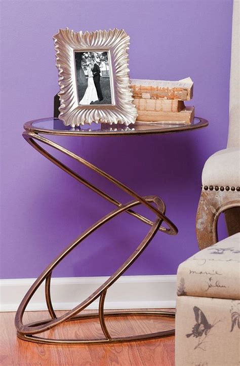 a chair and table with a picture frame on it in front of a purple wall