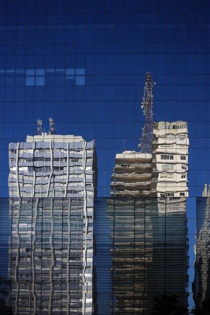 Premium Photo | A building with a reflection of a skyscraper in the windows of it.