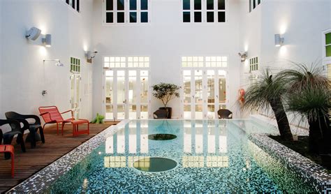 an indoor swimming pool surrounded by chairs and potted plants in the ...