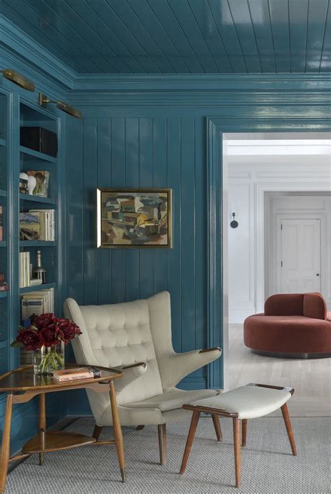 a living room filled with furniture and bookshelves covered in blue paint on the walls