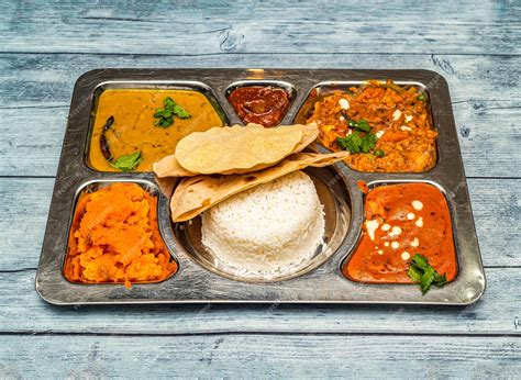 Premium Photo | North indian vegetarian meal thali with curry rice chapati and vegetables served ...