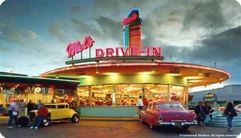 people are standing in front of a drive - in